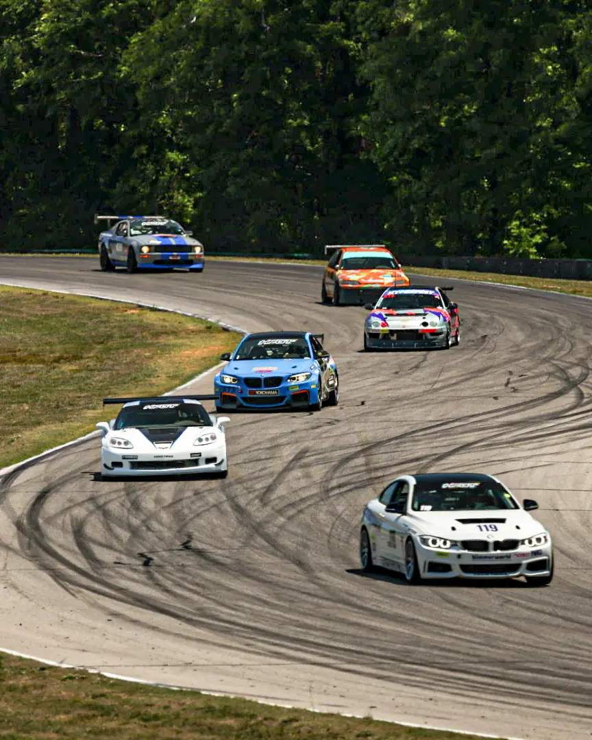 Cars racing wheel to wheel through a corner at Virginia International Raceway